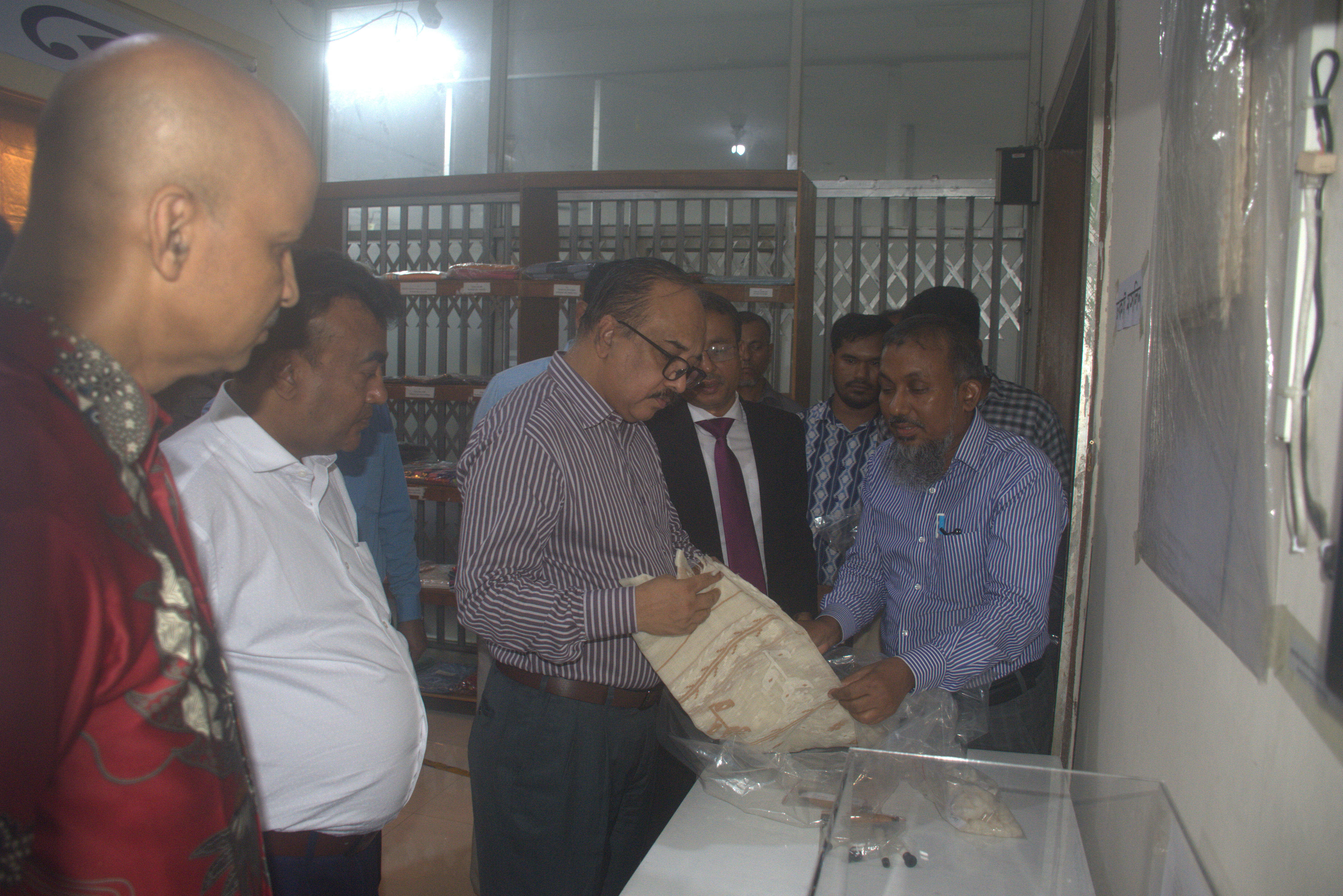 বস্ত্র ও পাট মন্ত্রণালয়ের সচিব মহোদয় কর্তৃক বাতাঁবো পরিদর্শনকালীন মসলিন কাপড় প্রদর্শন।