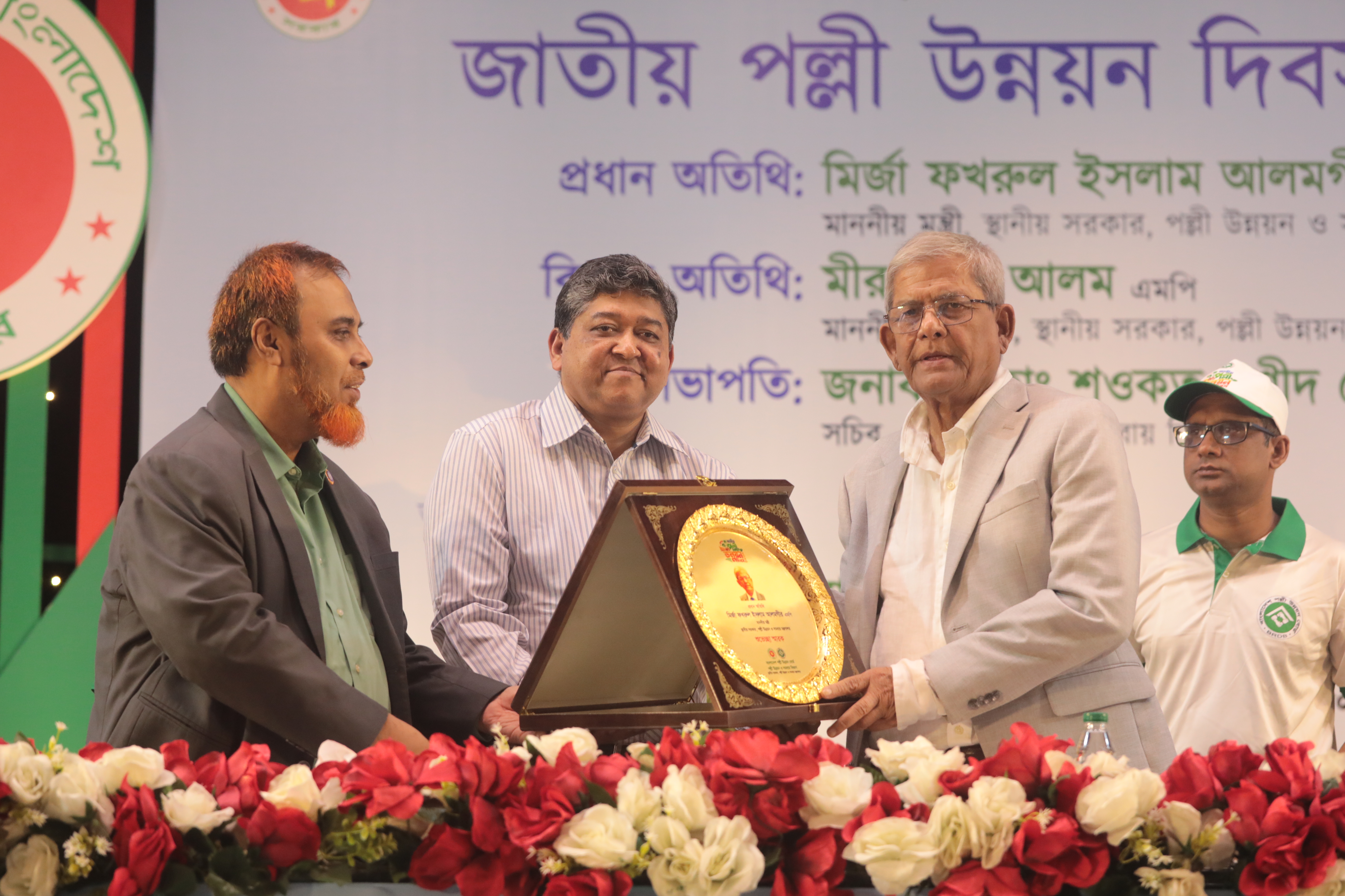 জাতীয় পল্লী উন্নয়ন দিবস ২০২৬ উদযাপন উপলক্ষে স্থানীয় সরকার, পল্লী উন্নয়ন ও সমবায় মন্ত্রণালয়ের মাননীয় মন্ত্রী জনাব মির্জা ফখরুল ইসলাম আলমগীর, এমপিকে ক্রেস্ট প্রদান করছেন বাংলাদেশ পল্লী উন্নয়ন বোর্ডের মহাপরিচালক জনাব একেএম তারেক।