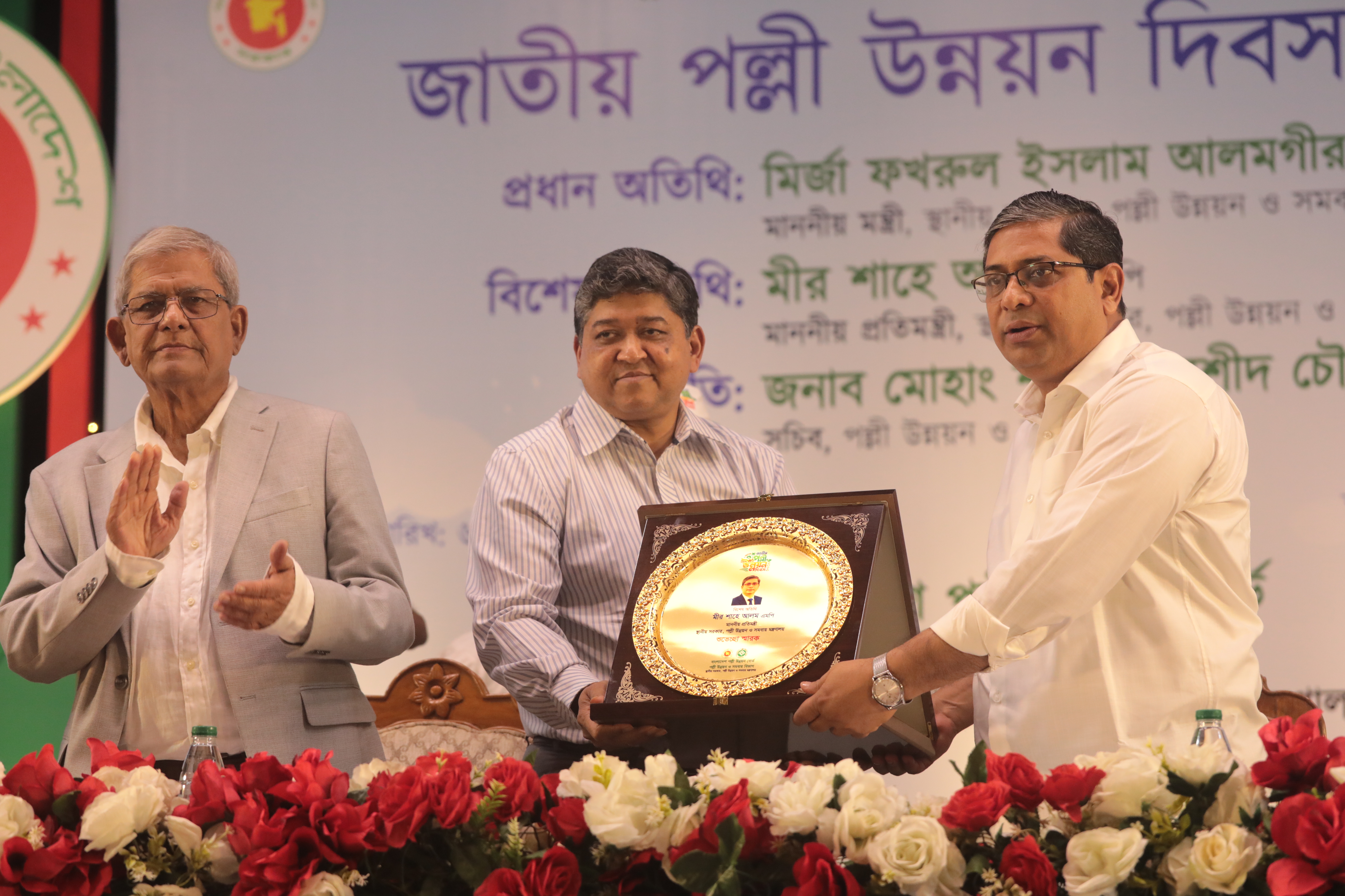 জাতীয় পল্লী উন্নয়ন দিবস ২০২৬ উদযাপন উপলক্ষে স্থানীয় সরকার, পল্লী উন্নয়ন ও সমবায় মন্ত্রণালয়ের মাননীয় প্রতিমন্ত্রী জনাব মীর শাহে আলম, এমপিকে ক্রেস্ট প্রদান করছেন বাংলাদেশ পল্লী উন্নয়ন বোর্ডের মহাপরিচালক জনাব একেএম তারেক।