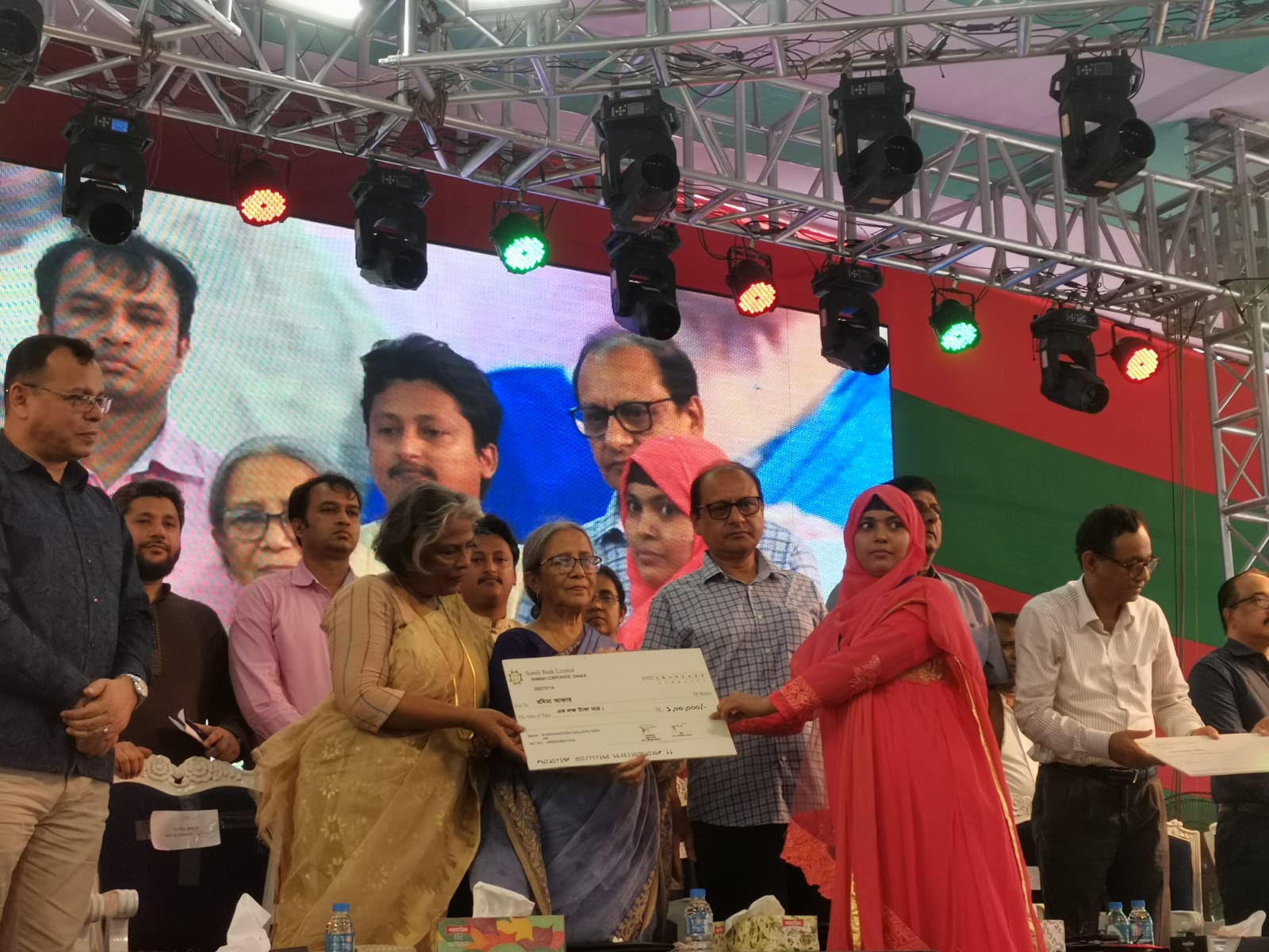 শহীদদের স্মরণে শ্রমিক সমাবেশ অনুষ্ঠানে কেন্দ্রীয় তহবিলের পক্ষ থেকে শ্রমিকদের চিকিৎসা সহায়তার জন্য চেক বিতরণ।