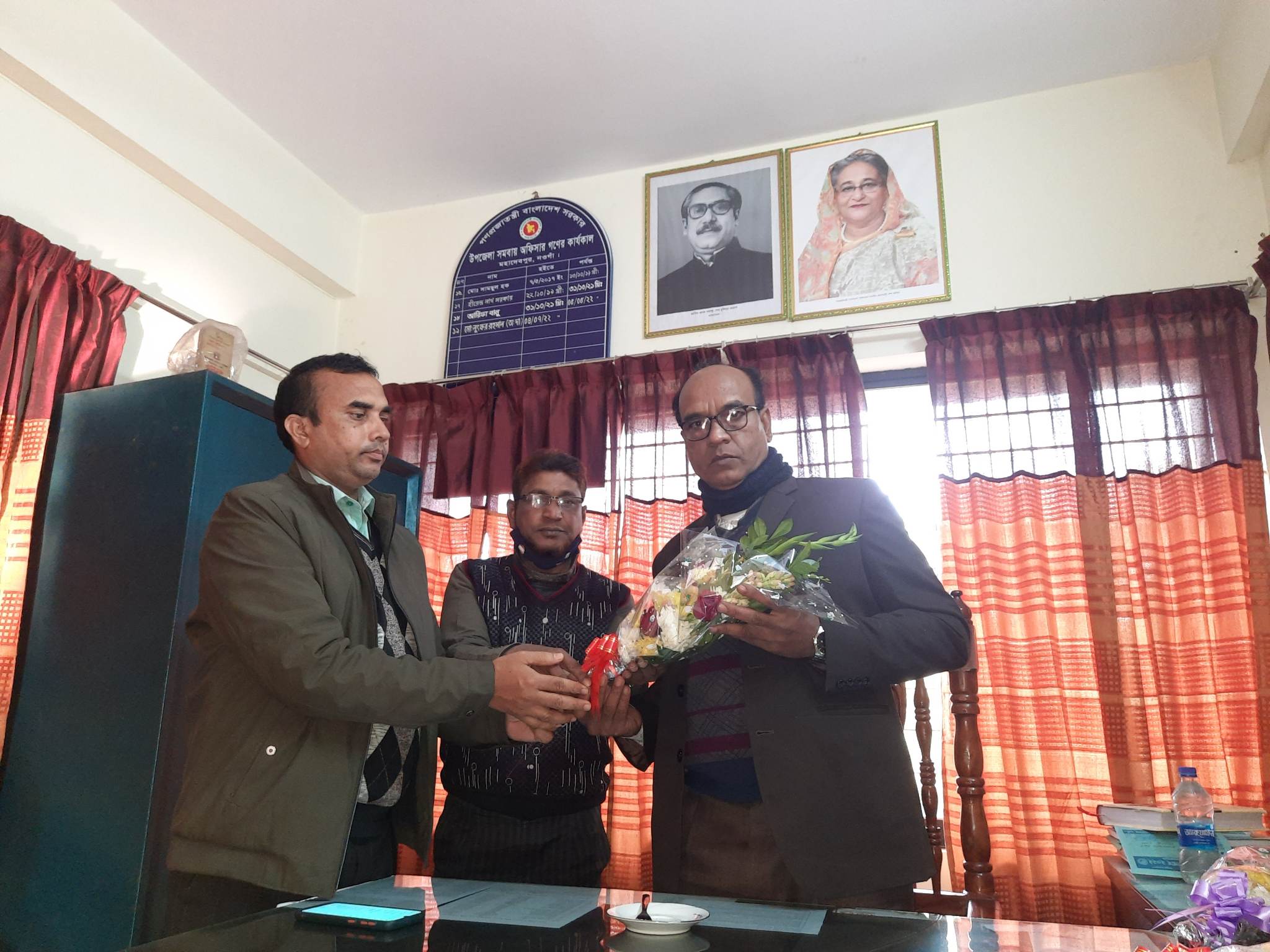জনাব মোঃ জাহাংগীর আলম, উপজেলা সমবায় অফিসার হিসেবে, মহাদেবপুর, নওগাঁ যোগদান করায় মহোদয় কে ফুলের তোড়া দিয়ে বরণের স্থিরচিত্র।