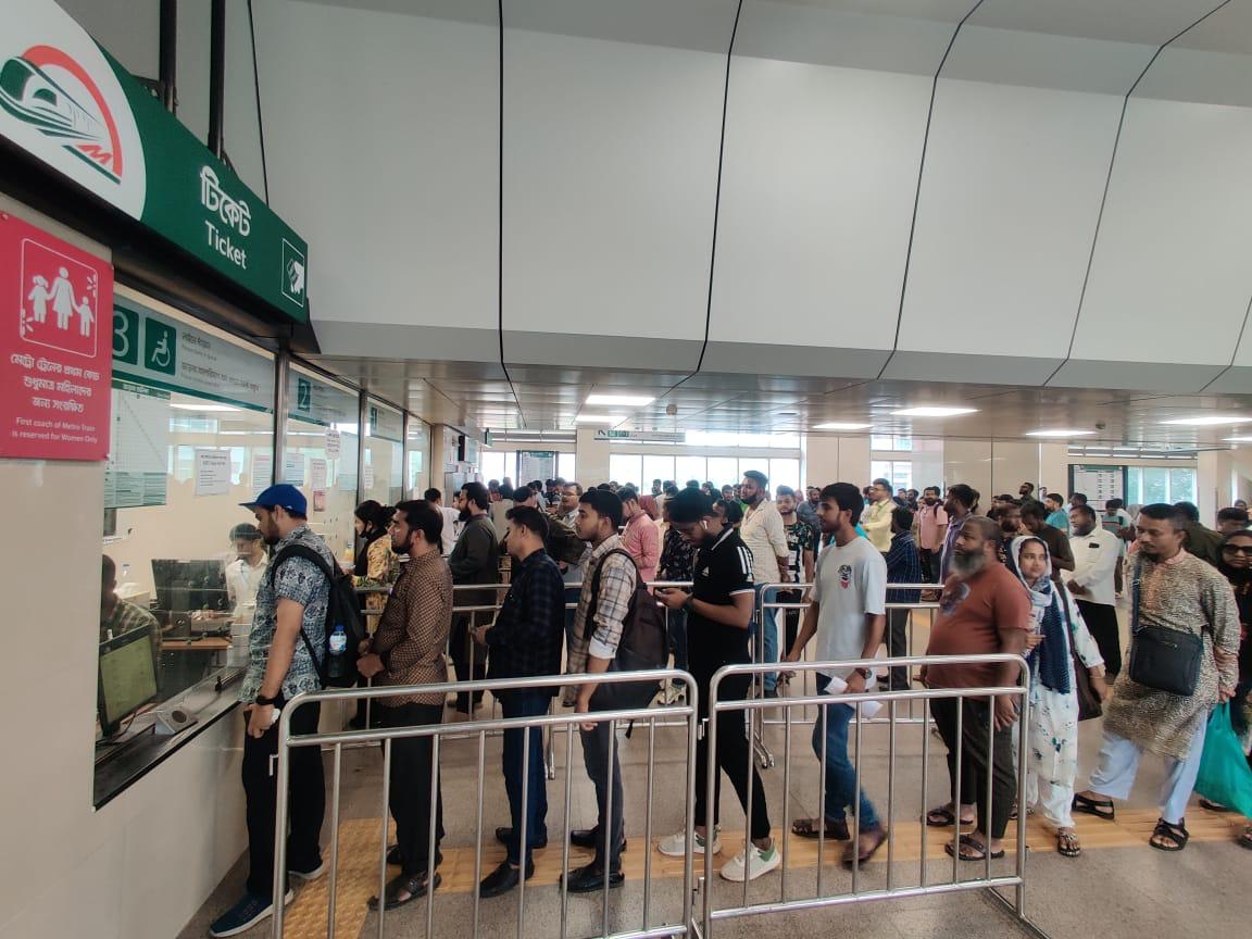মেট্রোরেলের যাত্রীগণ টিকেট বিক্রয় মেশিন থেকে শারিবদ্ধভাবে টিকেট সংগ্রহ করছেন