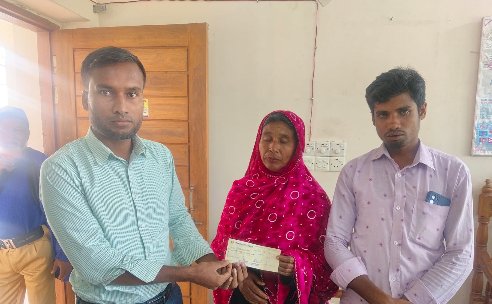 অগ্নিকান্ডে ক্ষতিগ্রস্ত ব্যক্তির মধ্যে চেক বিতরণ।