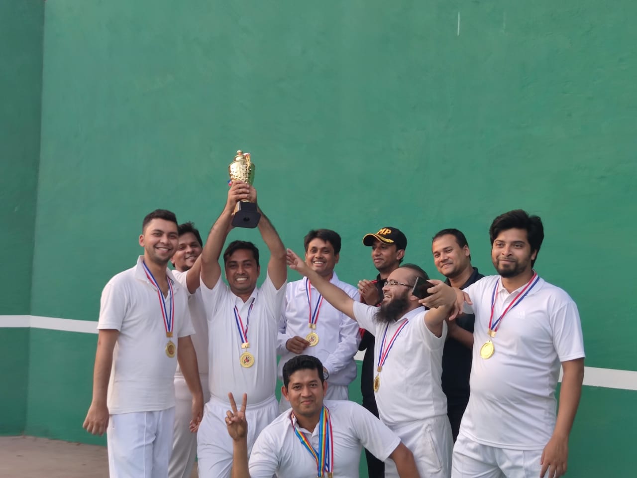 ক্রিকেট ম্যাচে বিজয়ী দলের ট্রফি হাতে উদযাপন